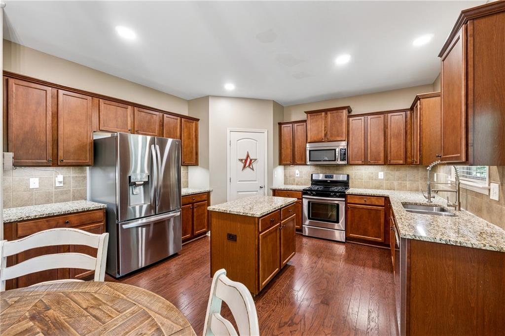 2770 Lansing Lane Cumming, GA 30041 - Photo 12 of 49 a kitchen with granite countertop stainless steel appliances and wooden cabinets