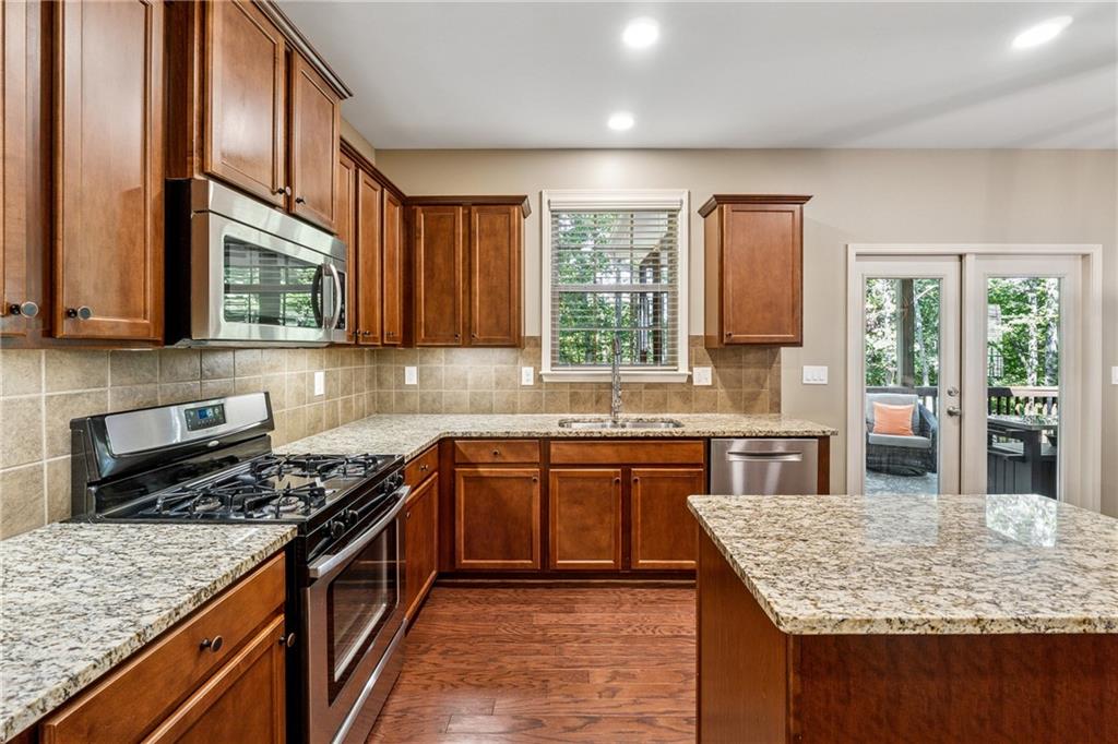 2770 Lansing Lane Cumming, GA 30041 - Photo 14 of 49 a kitchen with stainless steel appliances granite countertop wooden cabinets a stove top oven a sink and dishwasher