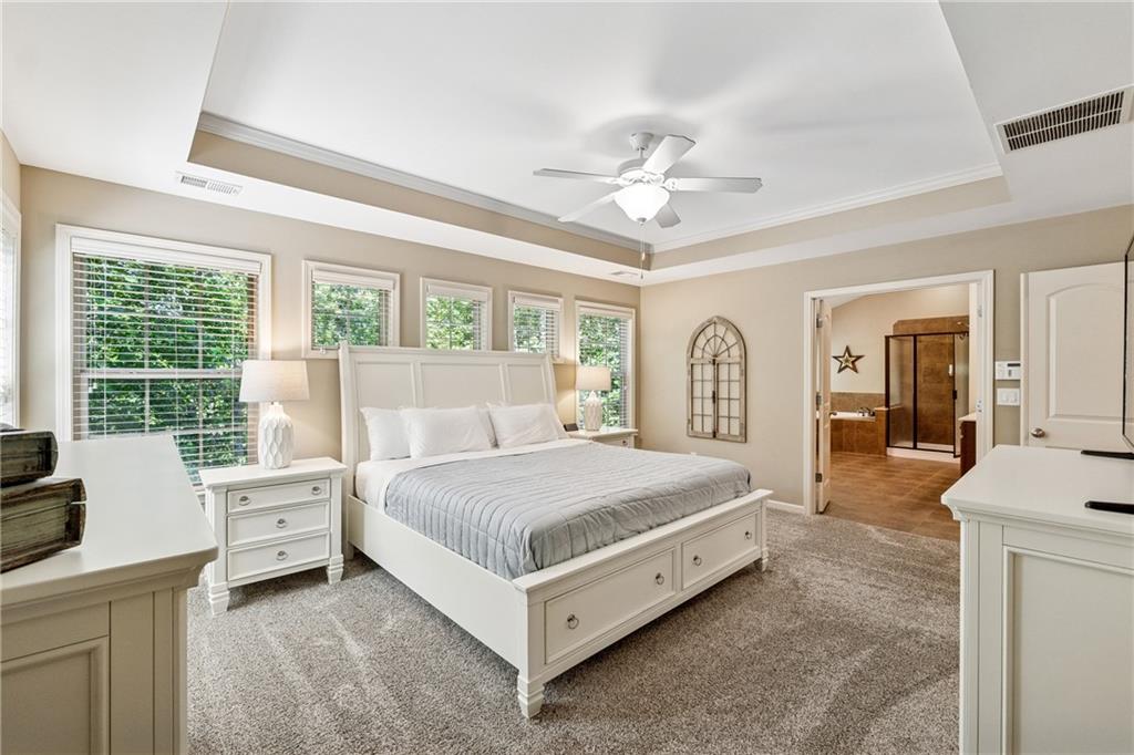2770 Lansing Lane Cumming, GA 30041 - Photo 17 of 49 a bedroom with a bed a large window and potted plants on the dresser