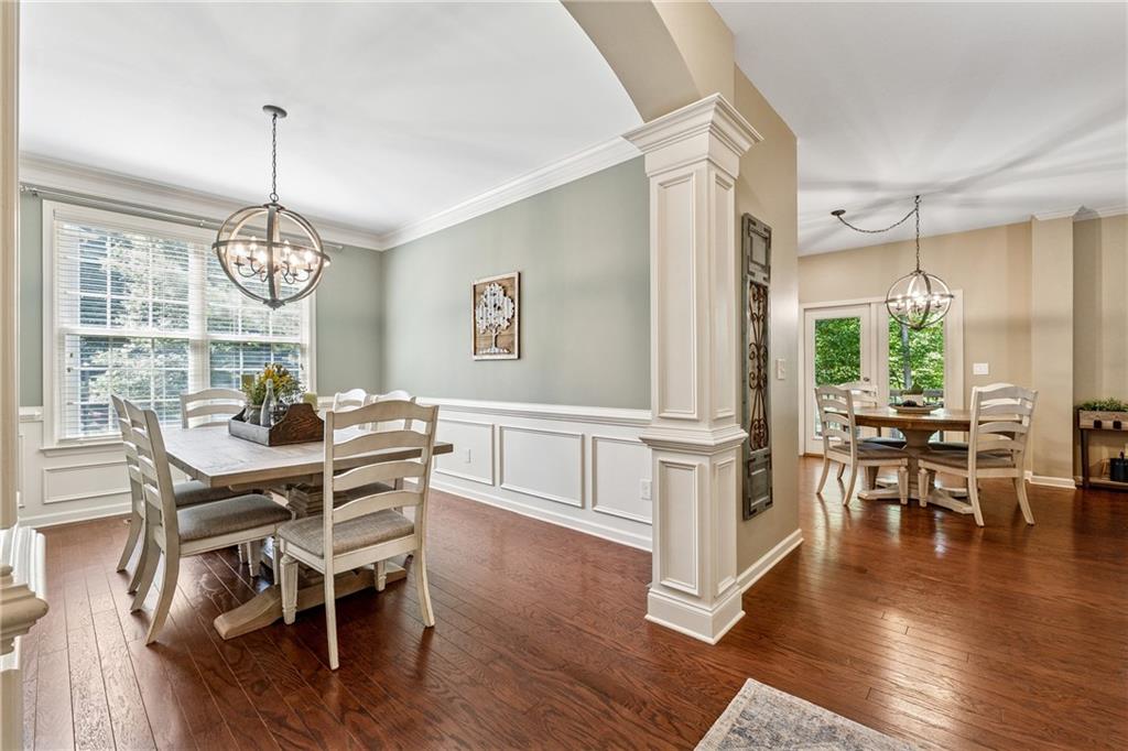2770 Lansing Lane Cumming, GA 30041 - Photo 8 of 49 a dining room with wooden floor a chandelier a wooden table and chairs