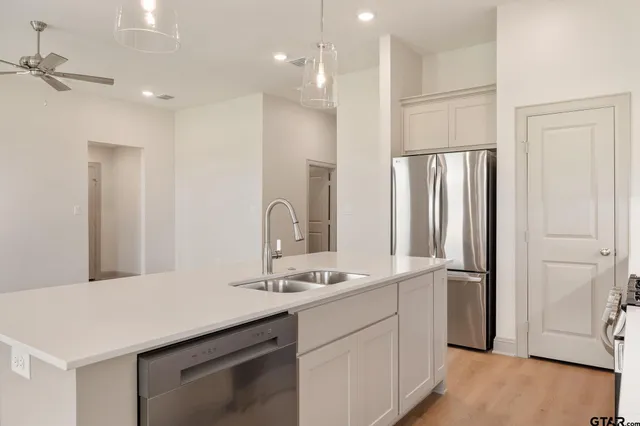 a kitchen with granite countertop white cabinets and stainless steel appliances