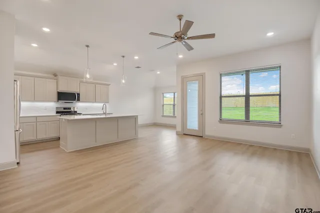 a kitchen with kitchen island a sink stainless steel appliances and cabinets
