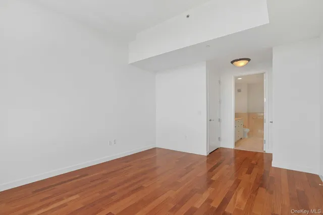 a view of a big room with wooden floor and windows