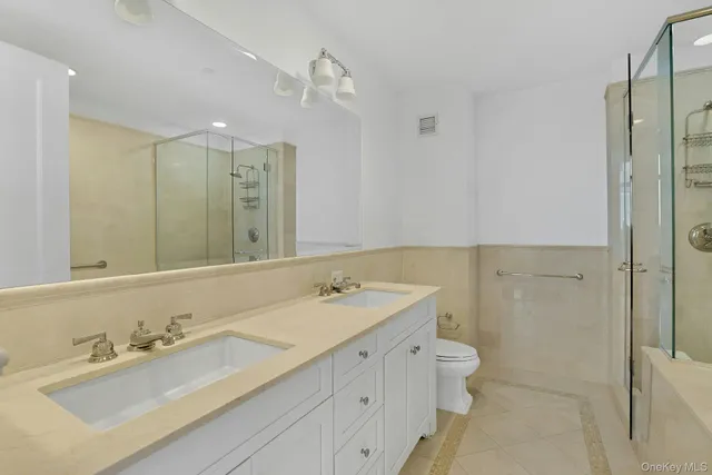 a bathroom with a double vanity sink mirror double and shower