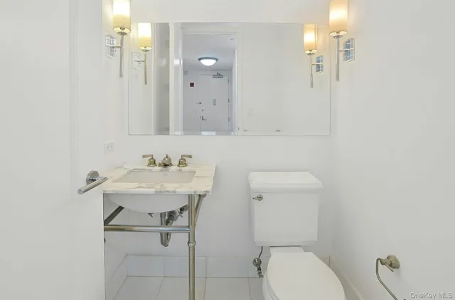 a bathroom with a sink a toilet and mirror