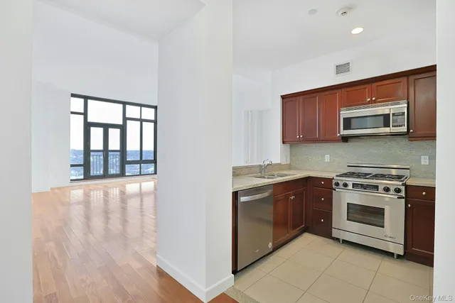 a kitchen with stainless steel appliances granite countertop a stove and a microwave