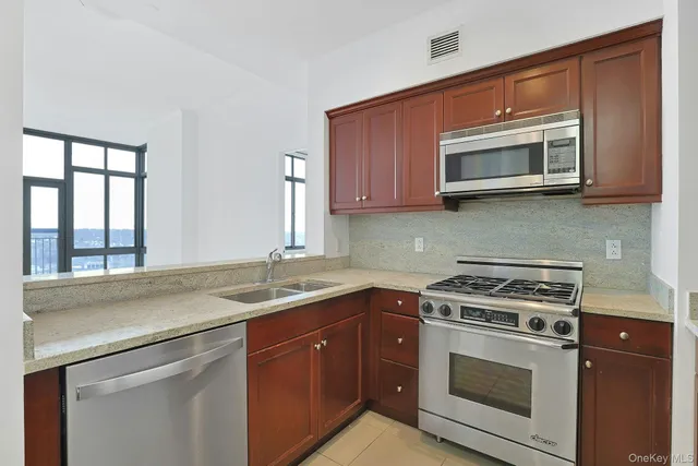 a kitchen with stainless steel appliances granite countertop a sink stove and microwave