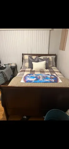 a bed sitting in a bedroom next to a lamp