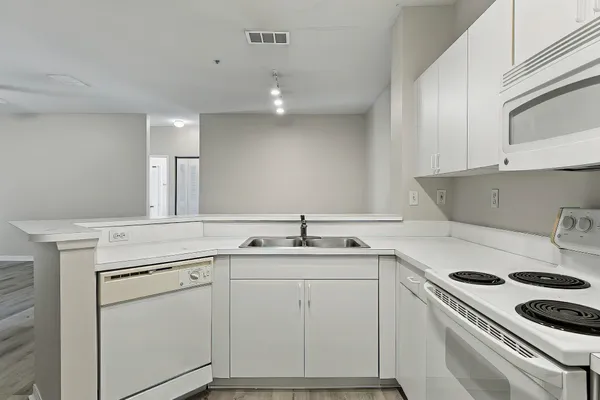 a kitchen with white cabinets and white appliances