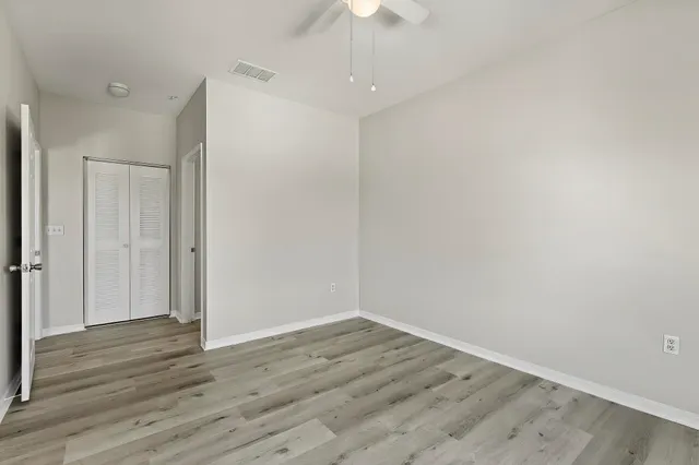 a view of an empty room with wooden floor