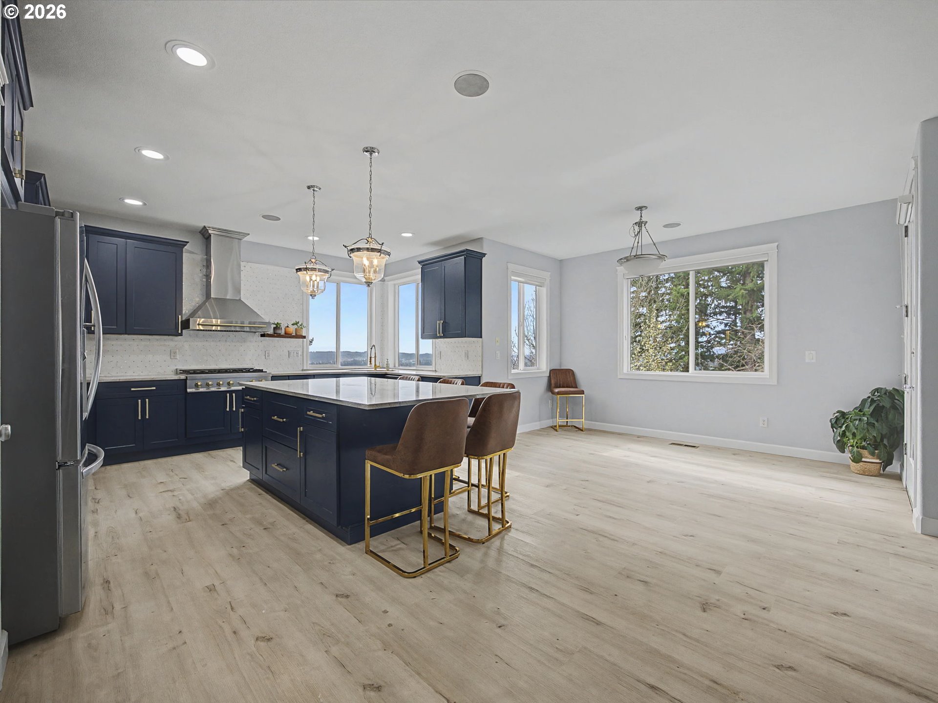 12410 Southwest Aspen Ridge Drive Tigard, OR 97224 - Photo 10 of 47 a kitchen with kitchen island granite countertop wooden floors and white cabinets