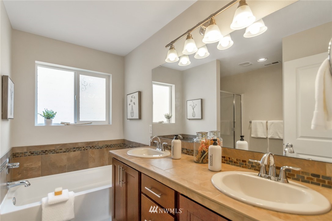 18615 35th Drive Southeast Bothell, WA 98012 - Photo 21 of 30 a bathroom with a tub a double vanity sink and a mirror