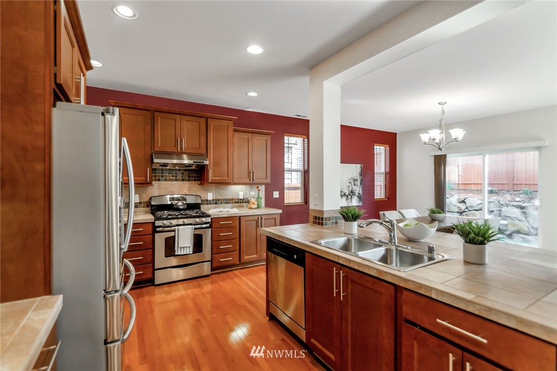 18615 35th Drive Southeast Bothell, WA 98012 - Photo 9 of 30 a kitchen with stainless steel appliances kitchen island granite countertop a stove refrigerator and cabinets