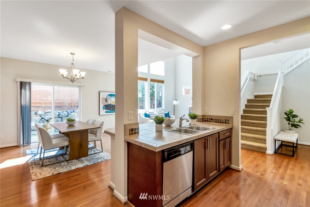 18615 35th Drive Southeast Bothell, WA 98012 - Photo 10 of 30 a open kitchen with stainless steel appliances granite countertop a stove and a table chair with wooden floor