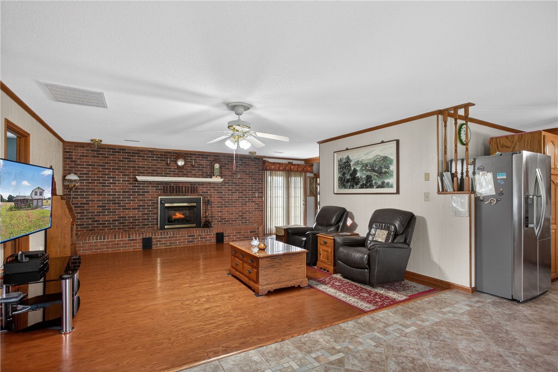 145 State Rd S-4-935 Pendleton, SC 29670 - Photo 6 of 47 A classic brick fireplace anchors this spacious living area with warm wood flooring and a contemporary ceiling fan.