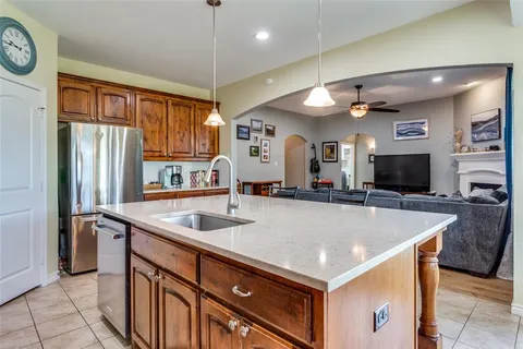 a kitchen with a stove a center island a sink cabinets and stainless steel appliances