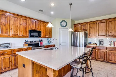 a kitchen with granite countertop a table chairs microwave and cabinets