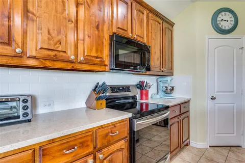a kitchen with stainless steel appliances granite countertop a sink a stove and a microwave