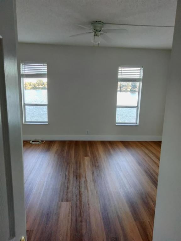 1100 Crystal Lake Drive, Unit 115 Deerfield Beach, FL 33073 - Photo 2 of 11 an empty room with wooden floor and windows