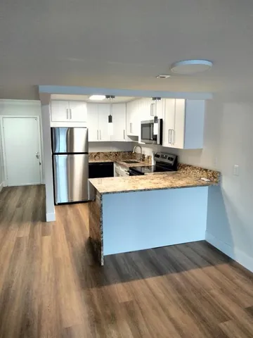 a kitchen with a refrigerator sink and cabinets