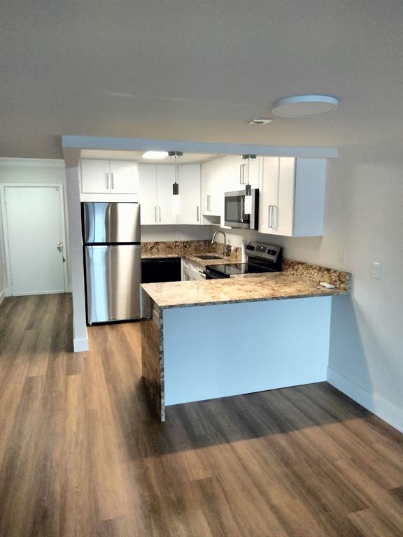 1100 Crystal Lake Drive, Unit 115 Deerfield Beach, FL 33073 - Photo 3 of 11 a kitchen with a refrigerator sink and cabinets