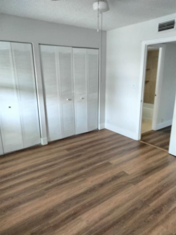 1100 Crystal Lake Drive, Unit 115 Deerfield Beach, FL 33073 - Photo 5 of 11 an empty room with wooden floor and entrance