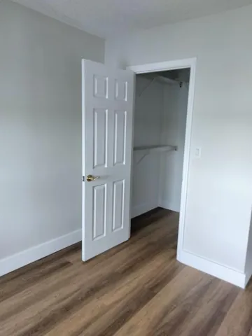 an empty room with wooden floor & door