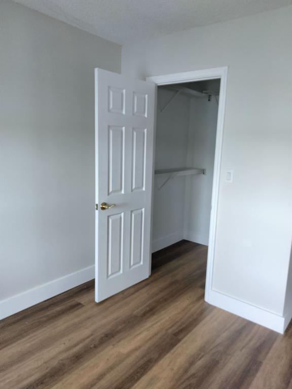 1100 Crystal Lake Drive, Unit 115 Deerfield Beach, FL 33073 - Photo 6 of 11 an empty room with wooden floor & door