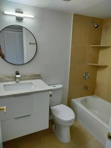 a bathroom with a sink mirror vanity and toilet