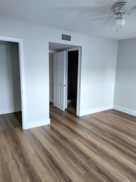 1100 Crystal Lake Drive, Unit 115 Deerfield Beach, FL 33073 - Photo 8 of 11 a view of an empty room with wooden floor and a window