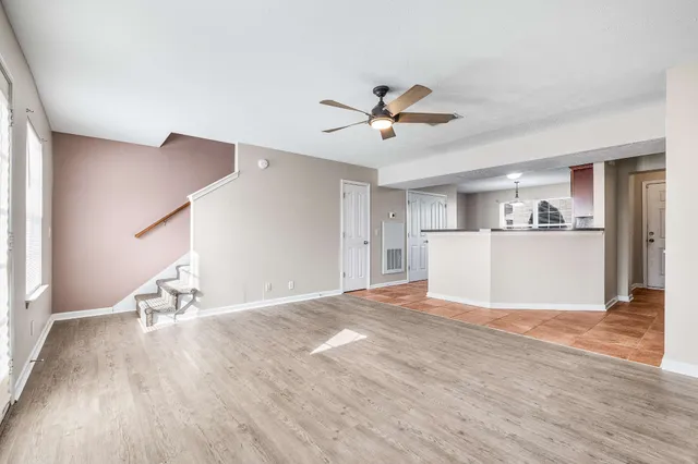 a view of a livingroom with wooden floor and a ceiling fan