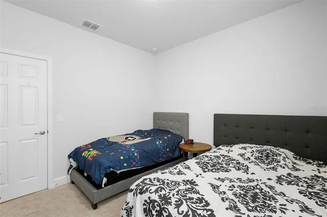 a bedroom with two beds and a lamp