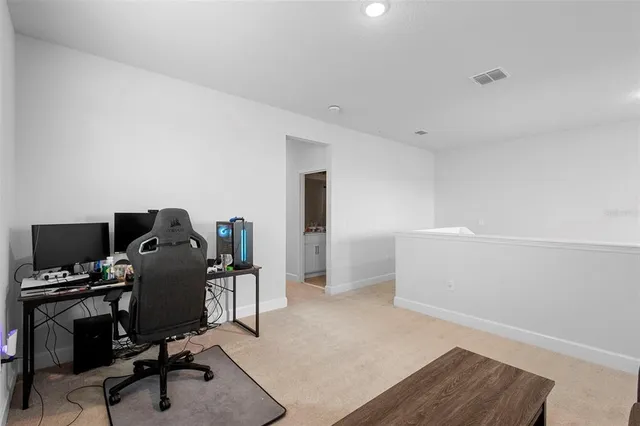 a view of a workspace with furniture and a window