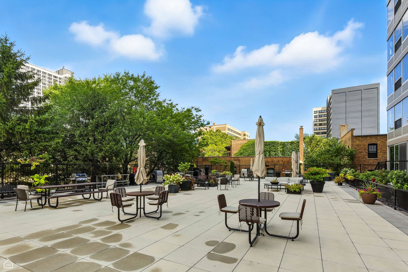 720 West Gordon Terrace, Unit 16E Chicago, IL 60613 - Photo 29 of 34 a view of a patio with a table and chairs and potted plants