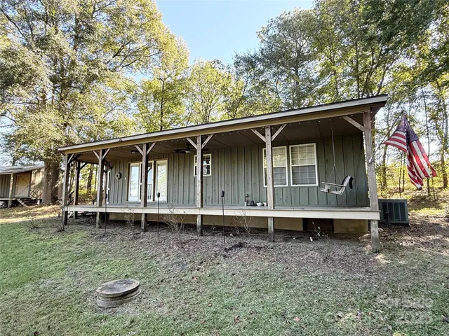 a backyard of a house with barbeque oven wooden fence and bench
