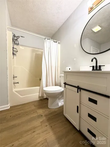 a bathroom with a granite countertop sink mirror toilet and bathtub