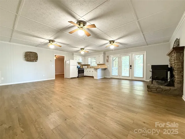 a view of empty room with wooden floor and a fireplace