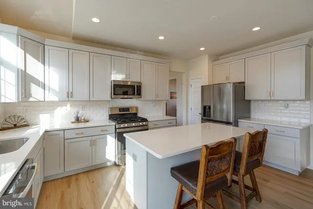 a kitchen with a table chairs refrigerator and microwave