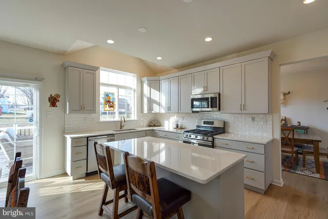 a kitchen with granite countertop a table chairs microwave and cabinets