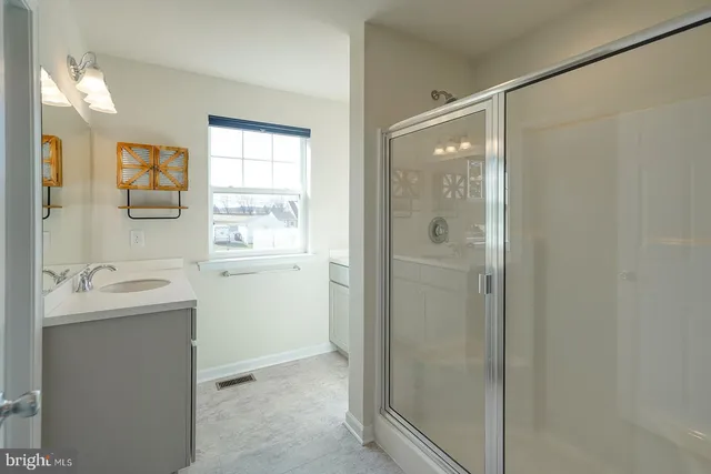 a bathroom with a sink mirror and a shower