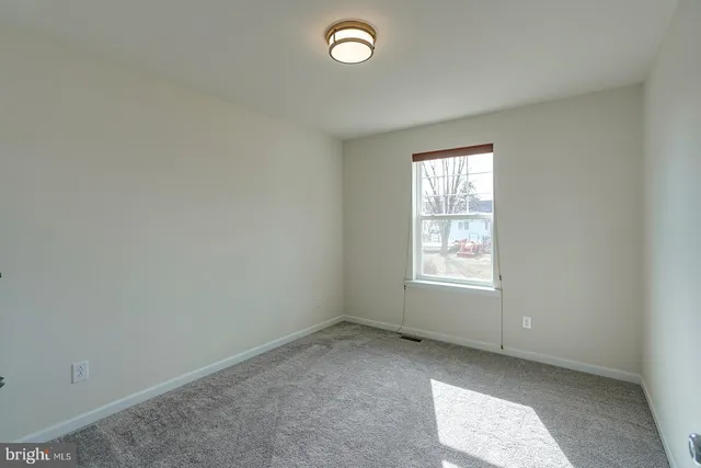 an empty room with a window and a mirror