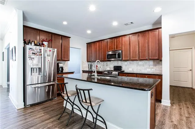 a kitchen with wooden cabinets and stainless steel appliances