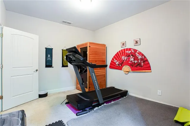 a room with gym equipment and wooden floor