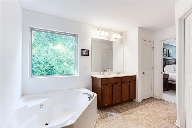 a bathroom with a tub sink and mirror
