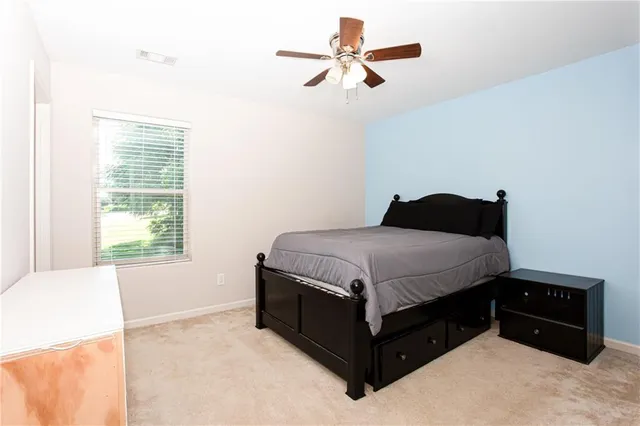 a bedroom with a bed dresser and a window