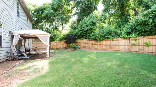 a view of backyard with a table and chairs and wooden fence