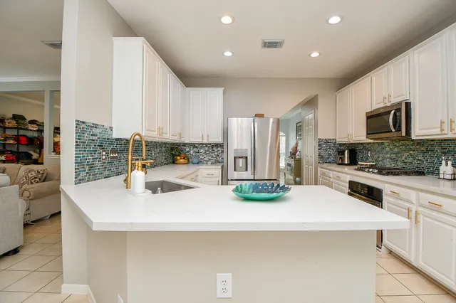 a kitchen with a sink a stove and chairs