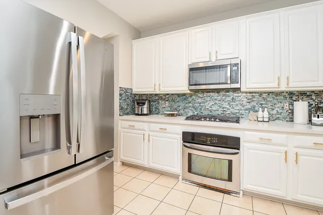 a kitchen with stainless steel appliances white cabinets and a granite counter tops