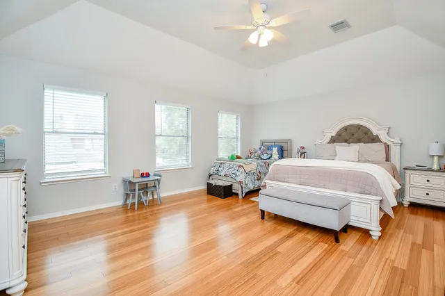 a bedroom with a bed and wooden floor