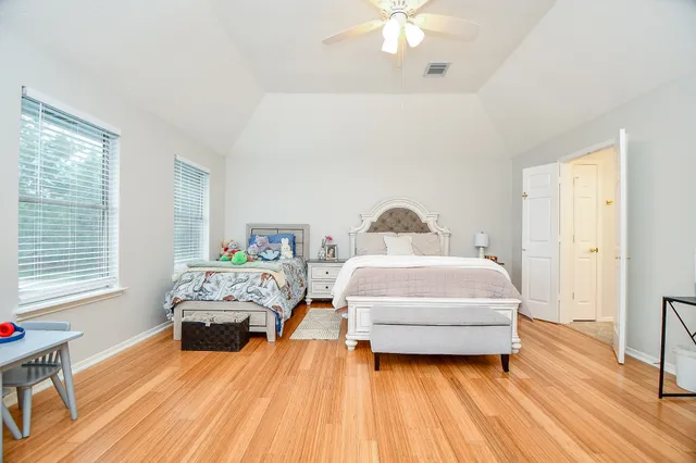 a bedroom with a bed and wooden floor